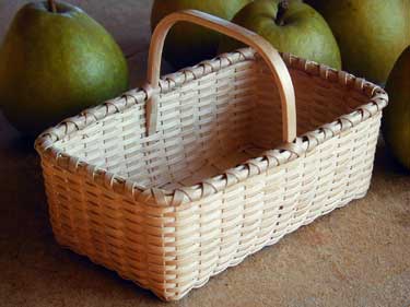 Tea Basket with pears. A rectangular basket with overhead handle handwoven of brown (black) ash splint in the tradition of the Maine basket makers by Stephen Zeh.